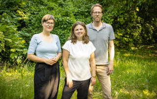 Bezirksstadträtin Annika Gerold, Bezirksbürgermeisterin Clara Herrmann und Bezirksstadtrat Florian Schmidt stehen im Grünen.