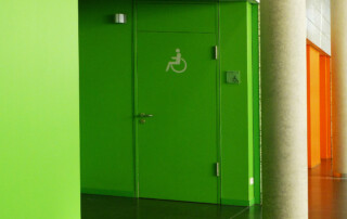 Grüne Tür einer inklusiven Toilette von Rainer Sturm / pixelio.de