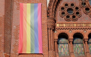 Regenbogenflagge an einer Kirchenfassade