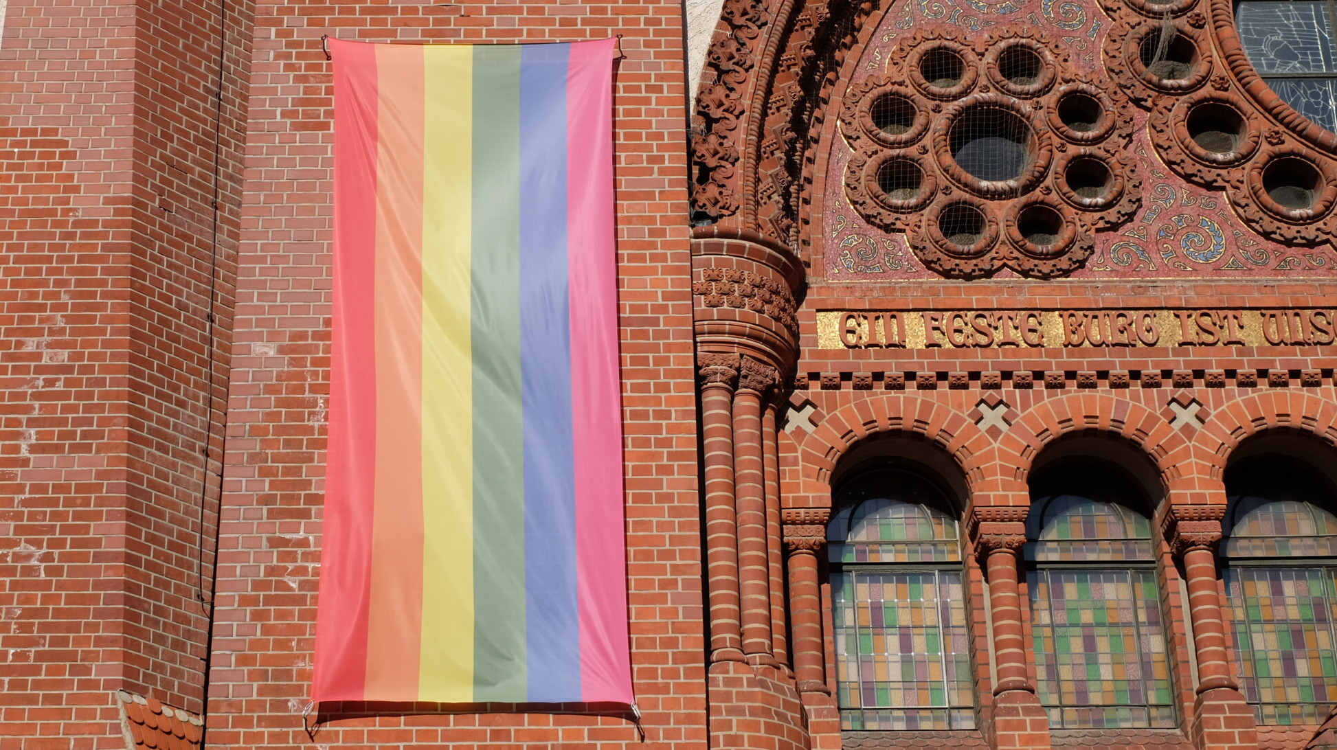 Regenbogenflagge an einer Kirchenfassade