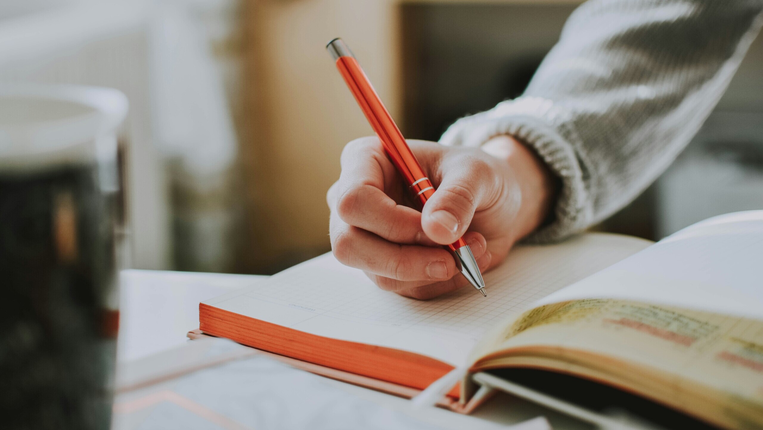 Hand schreibt in Heft von lilartsy / Unsplash.de